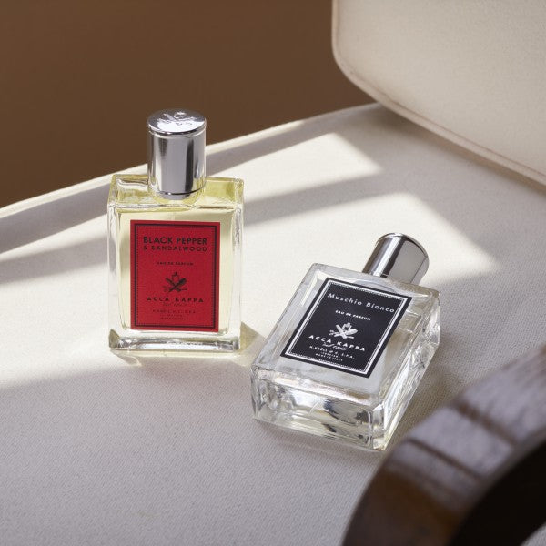 Two perfume bottles by Acca Kappa on a light surface with a soft background